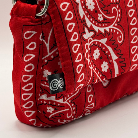 Red bag with white paisley pattern on a light beige background