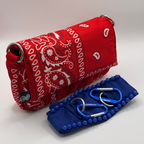 Red bandana-patterned pouch with a blue case containing medical tools on a white background