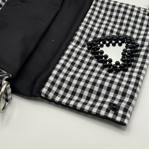 Black and white checkered bag with a black interior on a light gray background