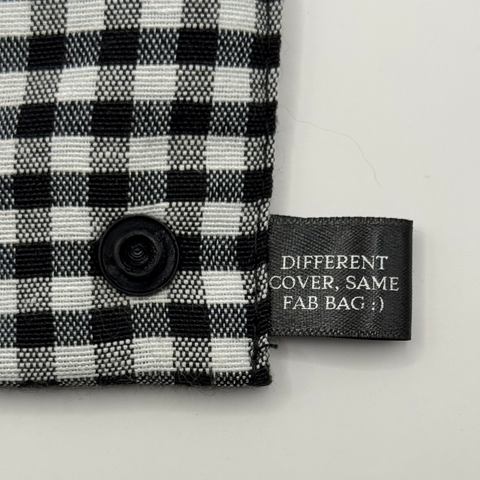 Black and white checkered fabric with a label reading 'Different cover, same fab bag :)' on a light gray background.