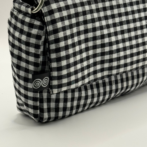 Black and white checkered pouch with a metal ring on a light gray background