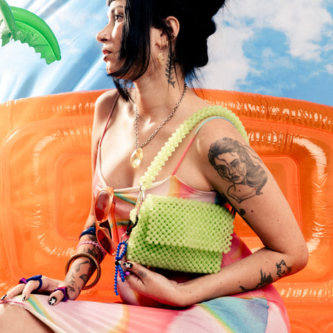 Woman sitting on an inflatable pool toy with a colorful background