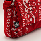 Red bag with white paisley pattern on a light beige background