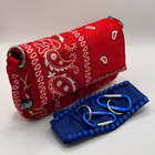 Red bandana-patterned pouch with a blue case containing medical tools on a white background